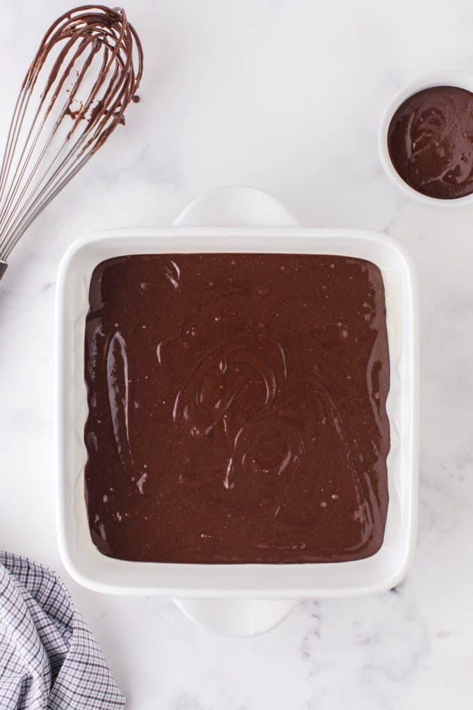 pouring brownie batter into the baking pan