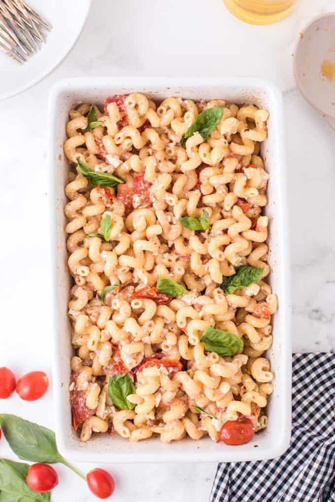 baked feta pasta in a baking dish topped with basil