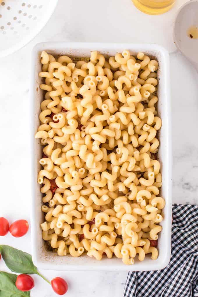 cooked pasta on top of the mixture in a baking dish