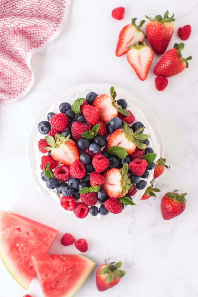 raspberries, blueberries, and strawberries on top of the watermelon cake
