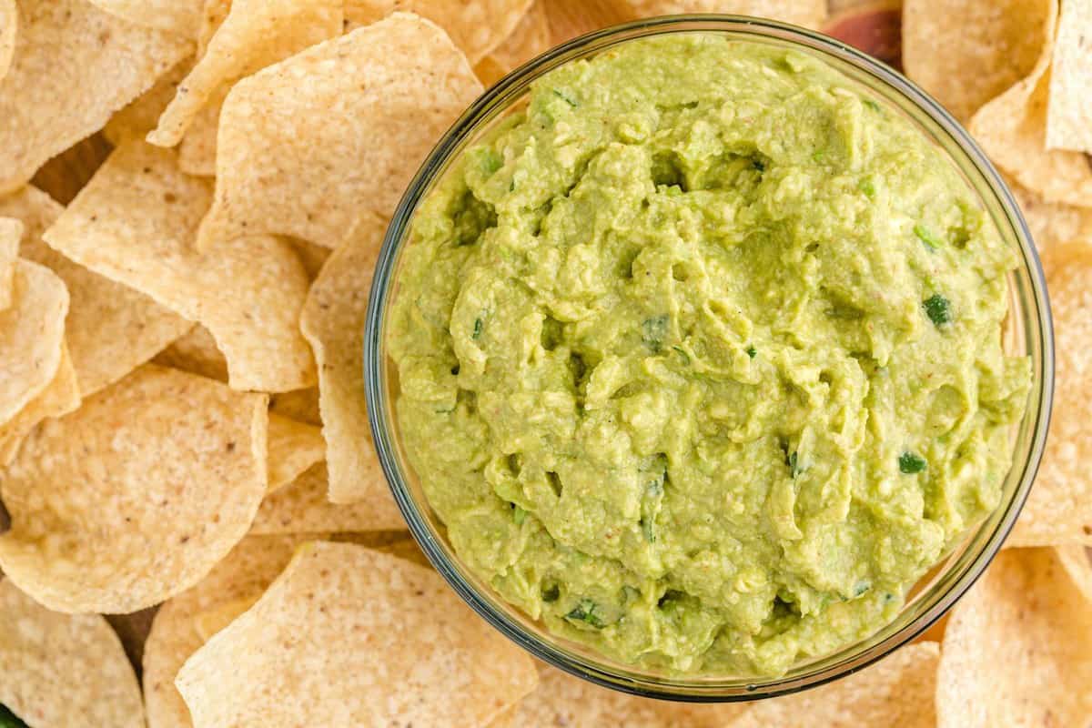 guacamole in a bowl in the middle of chips