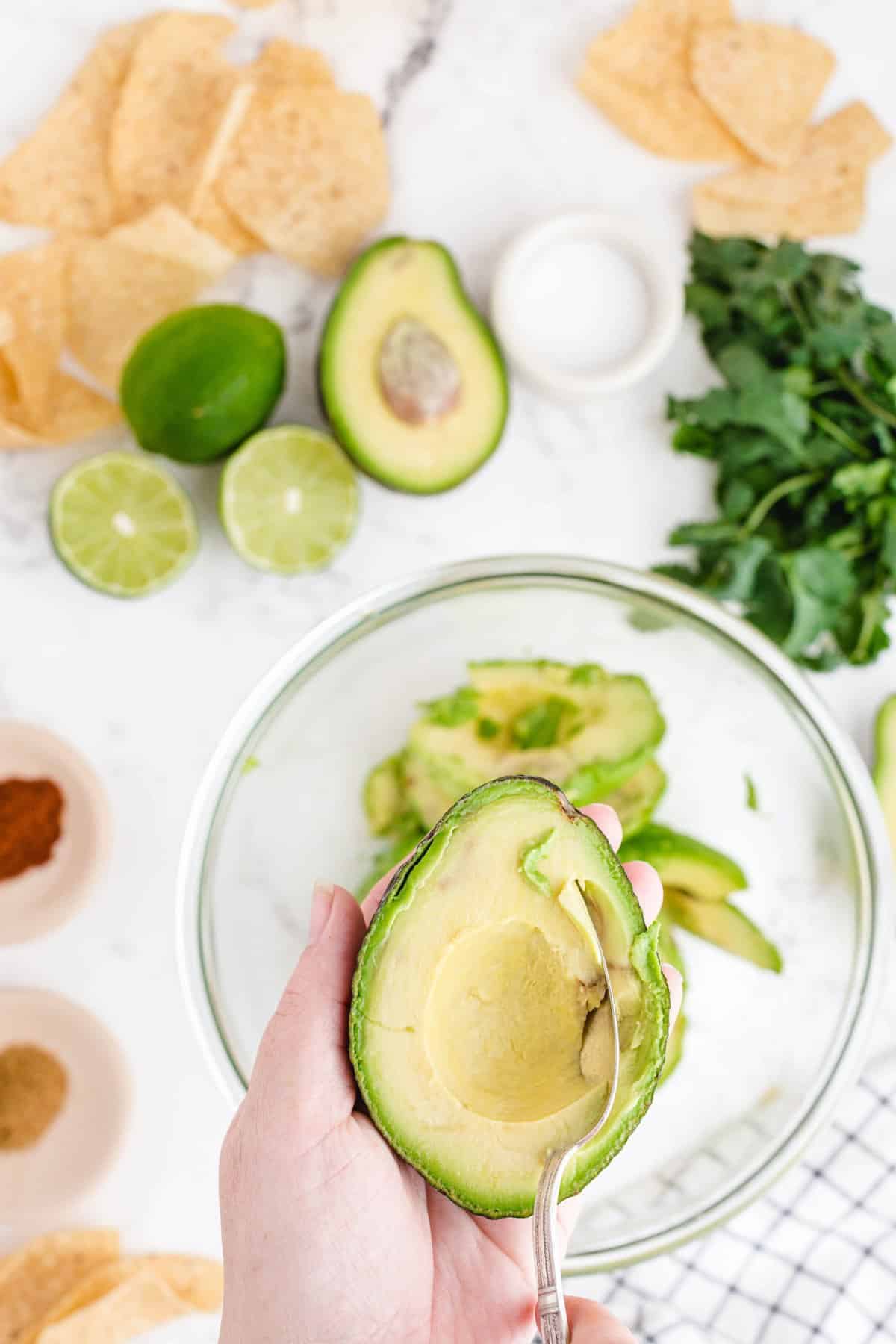 Slice avocados in half, remove pits, and scoop them into a bowl