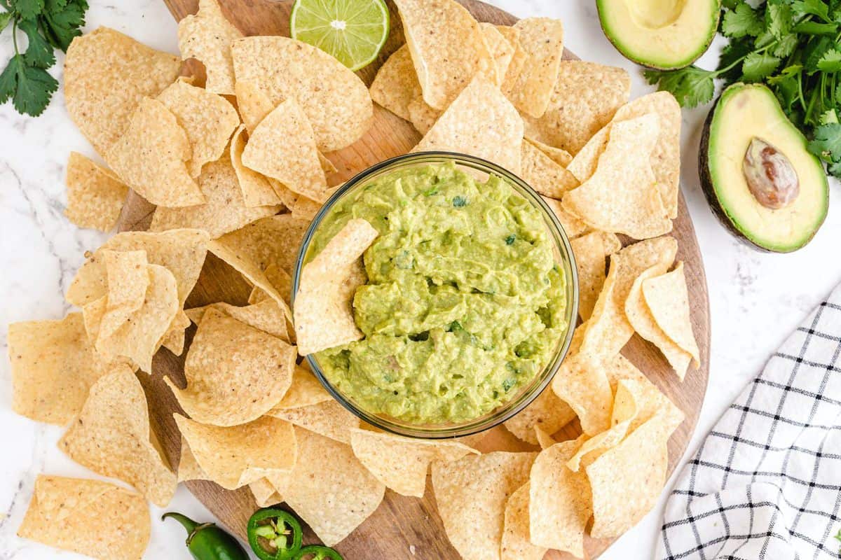 guacamole in a bowl with chips dipped in