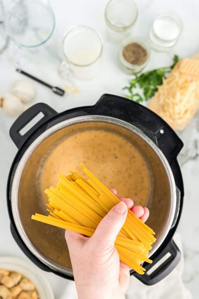 placing fettuccini into the Instant Pot 