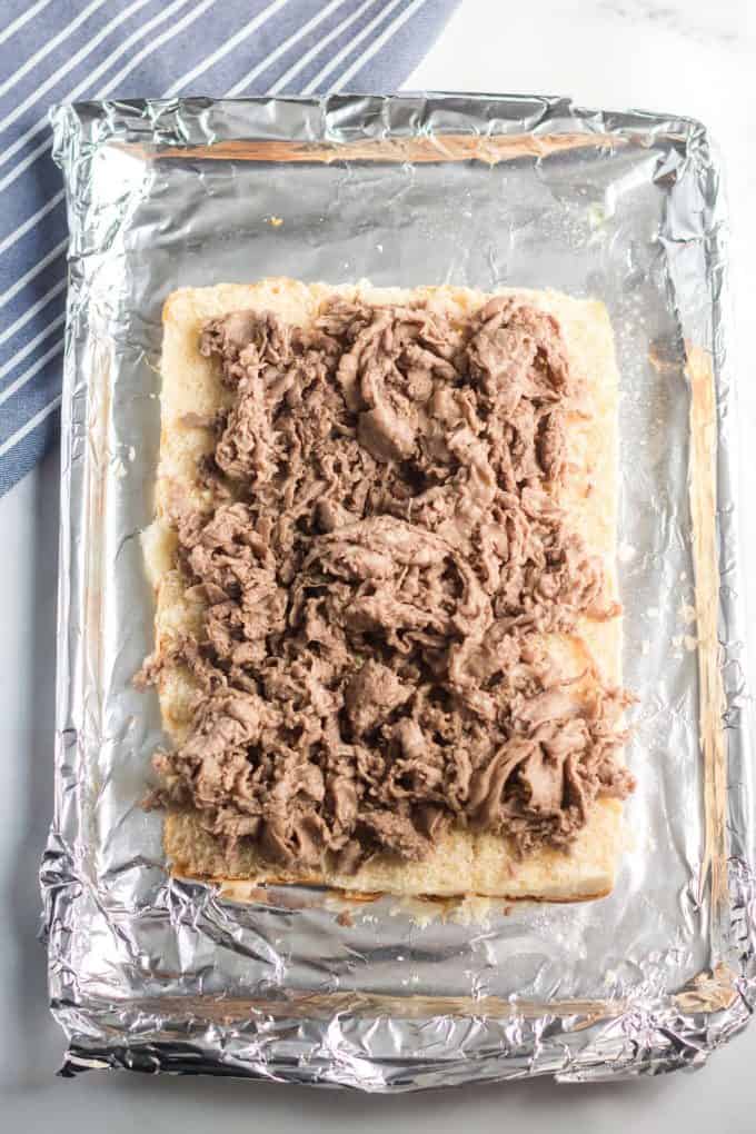 placing the steak on top of the bottom slab of rolls