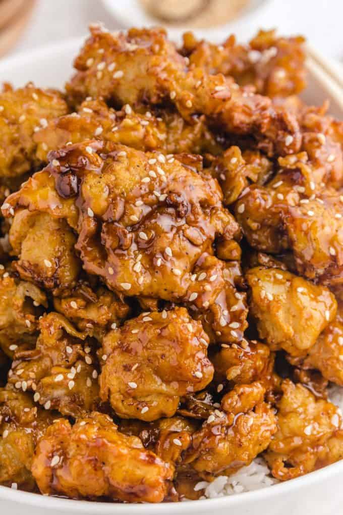 close up image of sesame chicken in a bowl