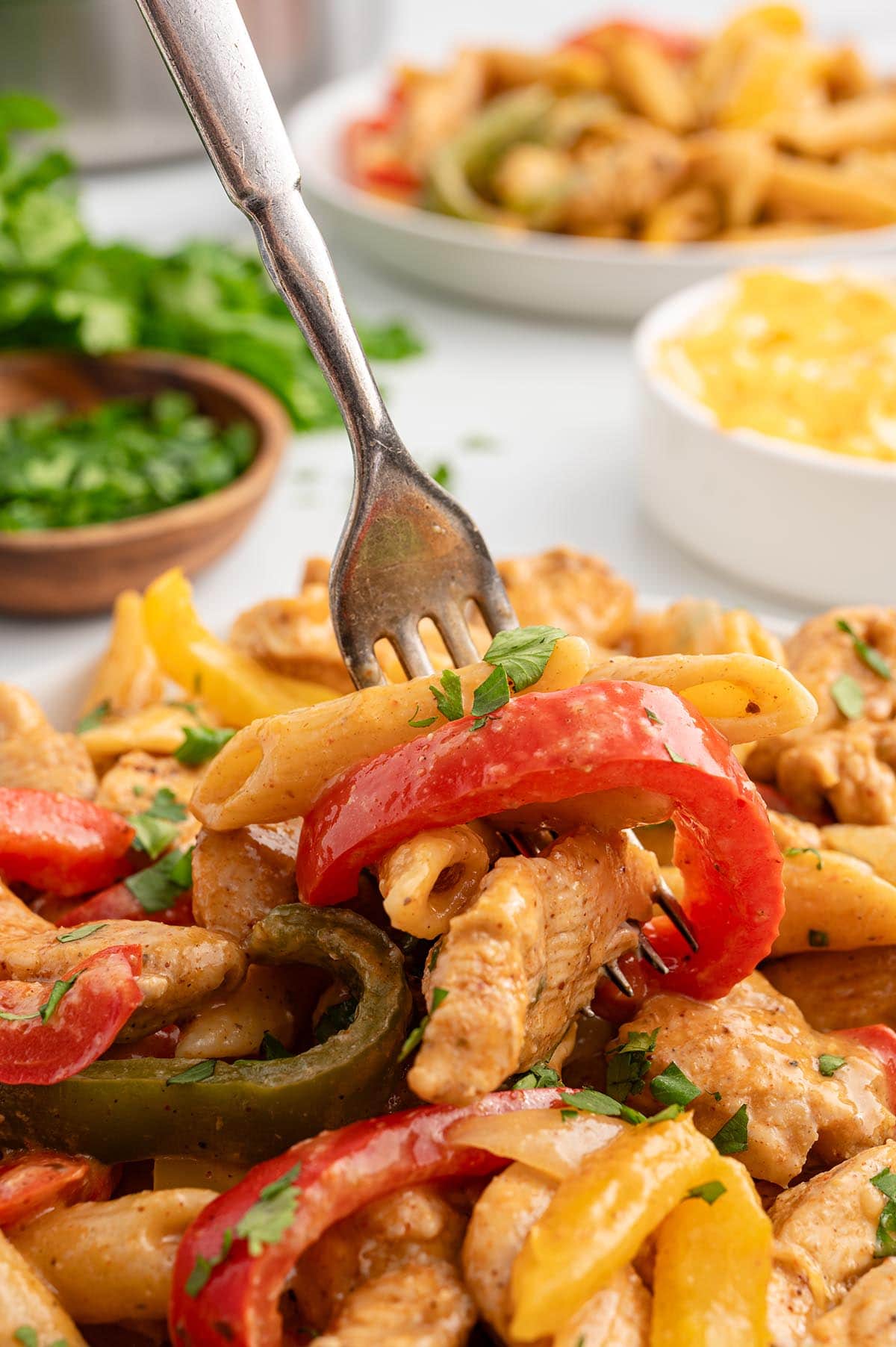 one pot chicken fajita pasta on a plate garnished with fresh cilantro.