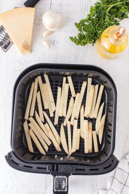 uncooked fries placed in the air fryer basket
