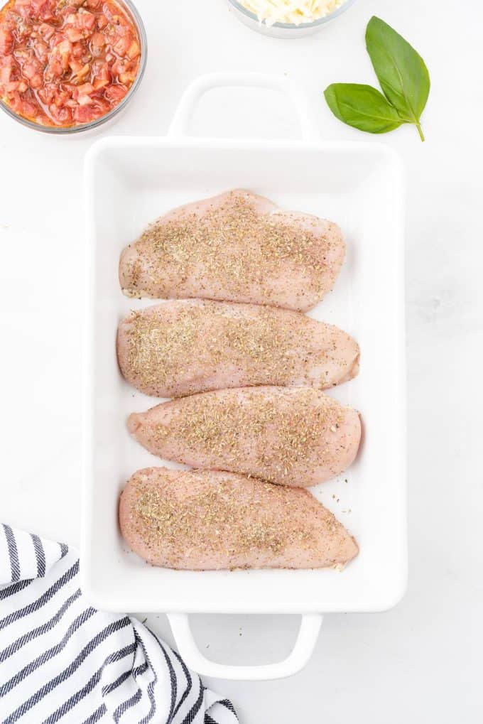 place the raw chicken in baking dish and brush it with seasonings