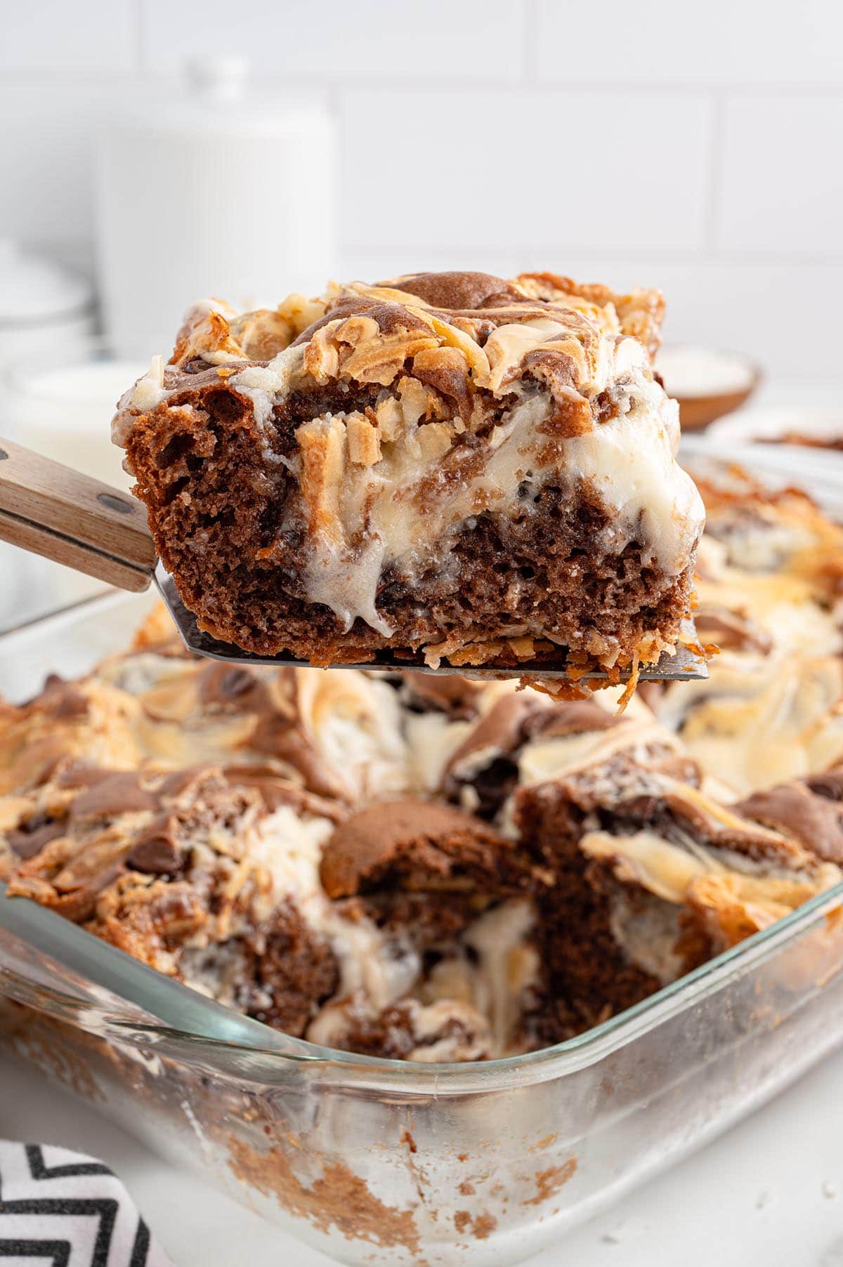 Earthquake Cake slice lifted from a glass baking dish.