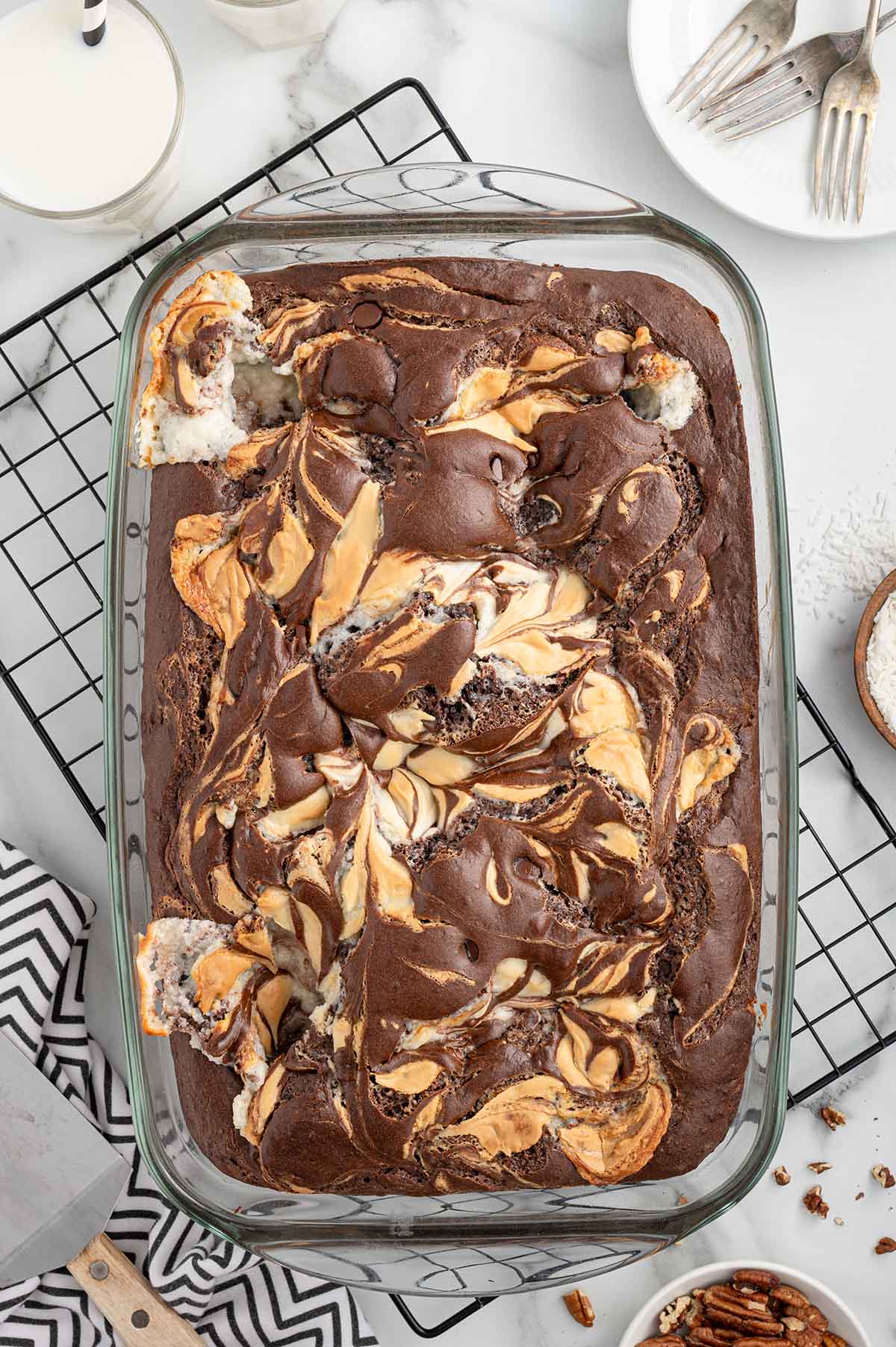 Earthquake Cake with a marbled mix of chocolate, cream cheese, and coconut in a glass dish on a cooling rack.