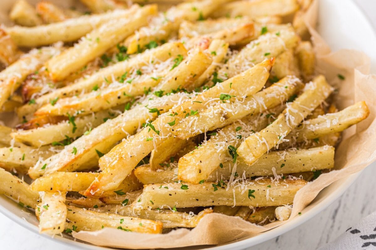 garlic parmesan fries served inside a white plate. 