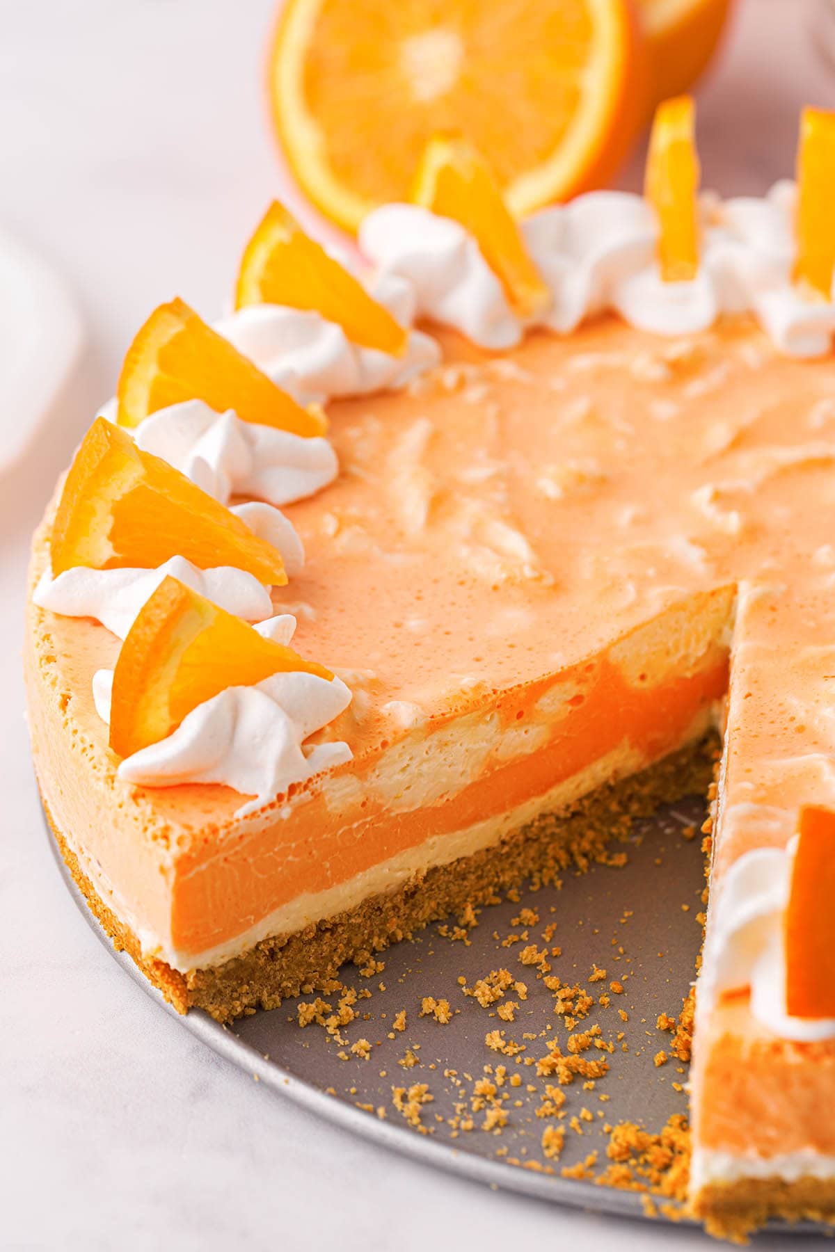 orange creamsicle cheesecake with a slice taken out. 