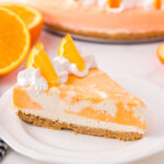 Orange creamsicle cheesecake on plate.