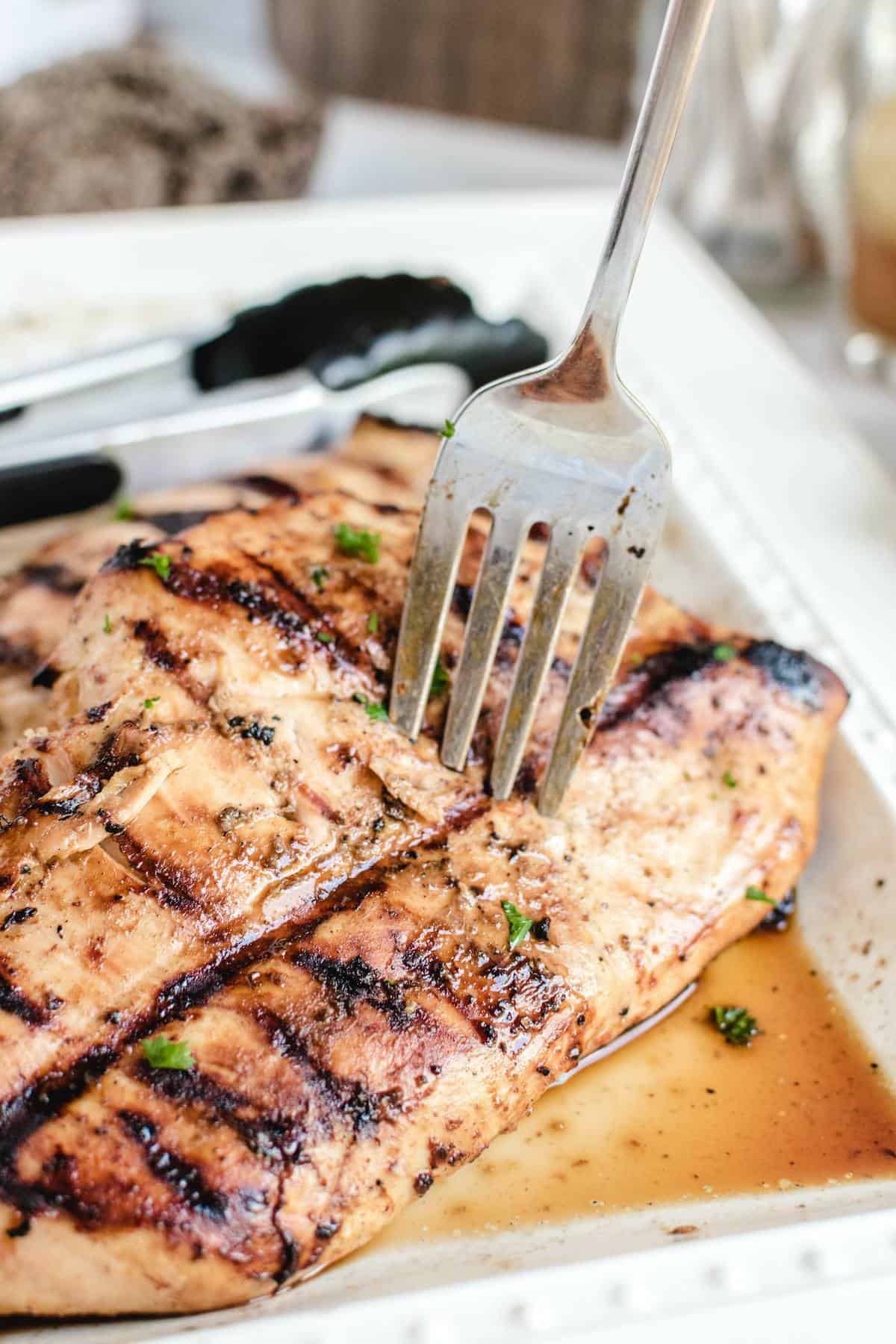 grilled chicken breast on a plate with fork