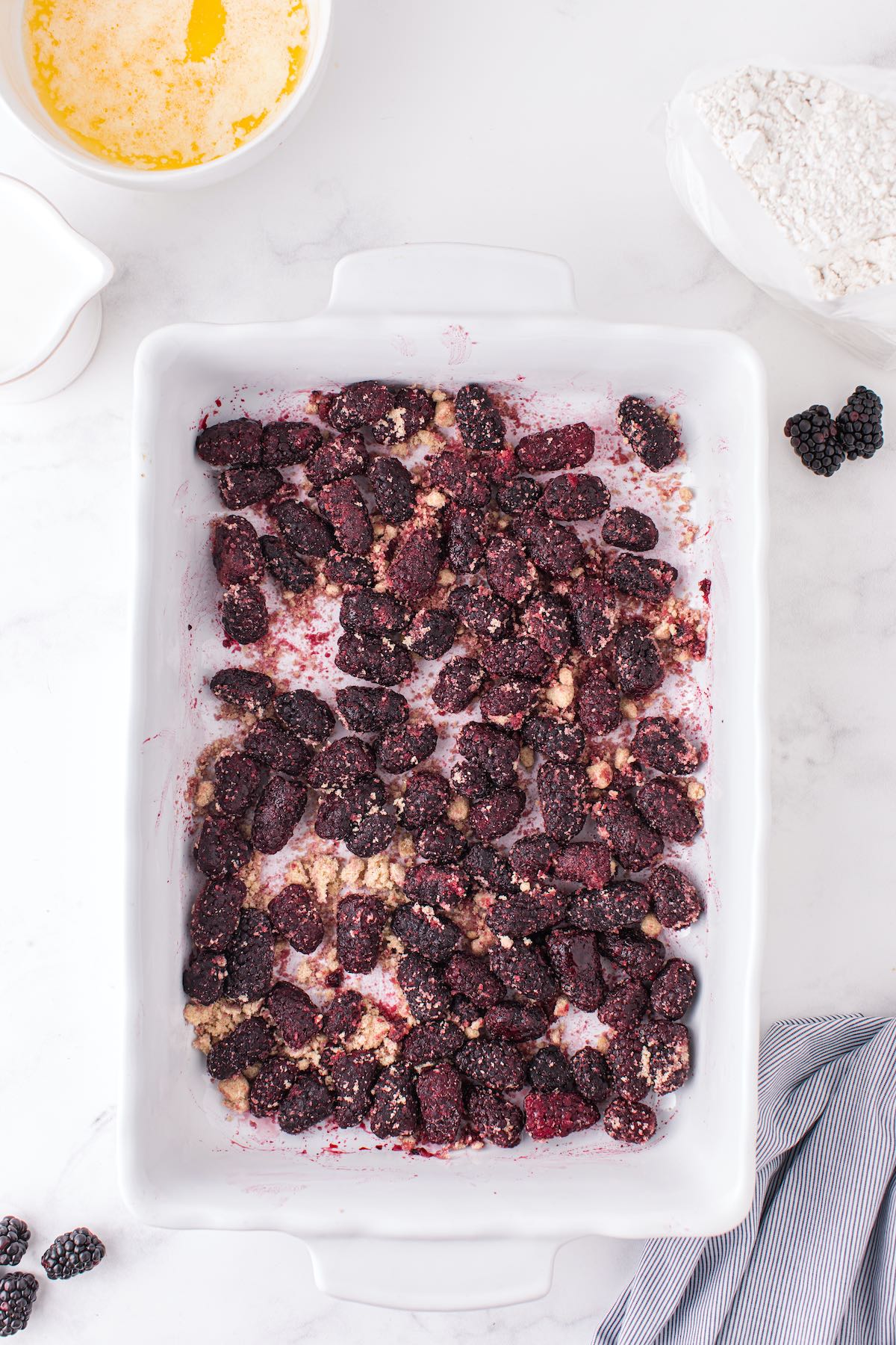 frozen blackberries at the bottom of the baking pan