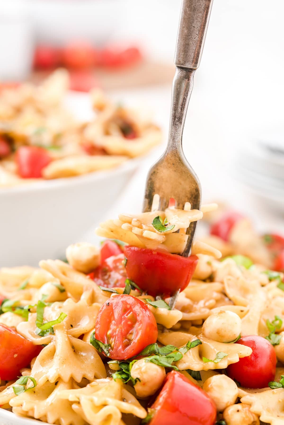 caprese pasta salad in a bowl with fork