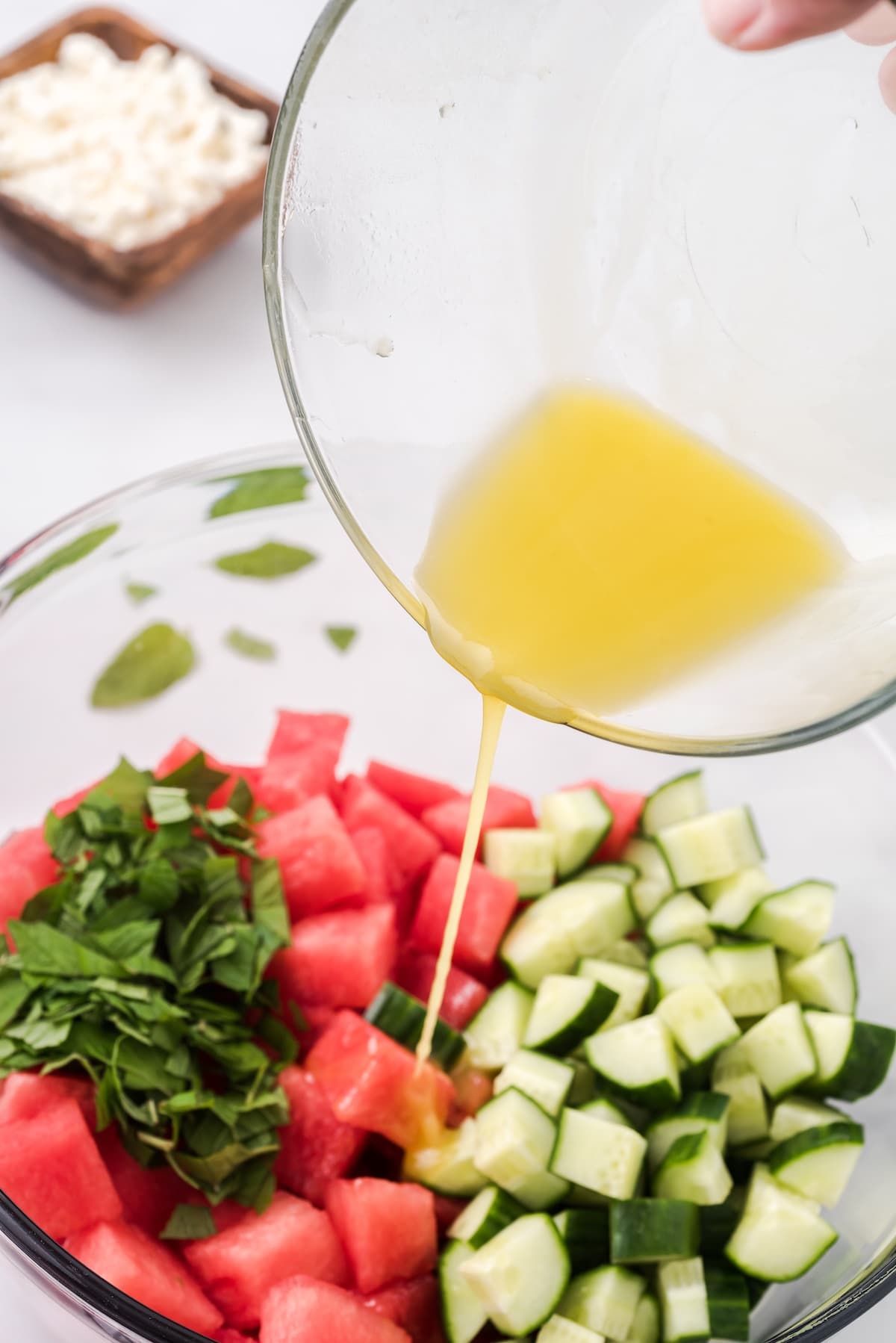 pour the dressing over the watermelon and cucumber
