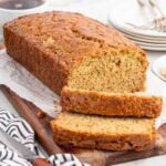 zucchini bread sliced into a couple pieces on top of wooden board.