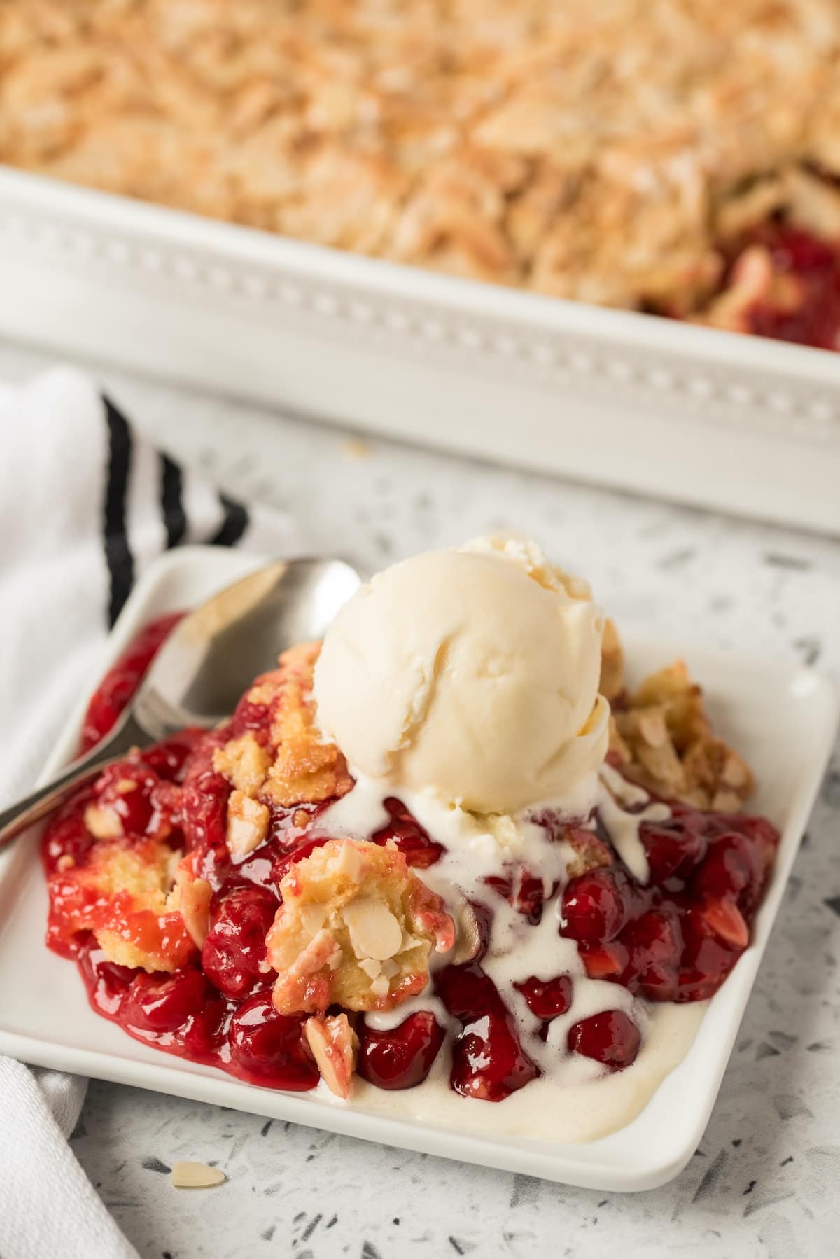 cherry dump cake on a plate served with ice cream