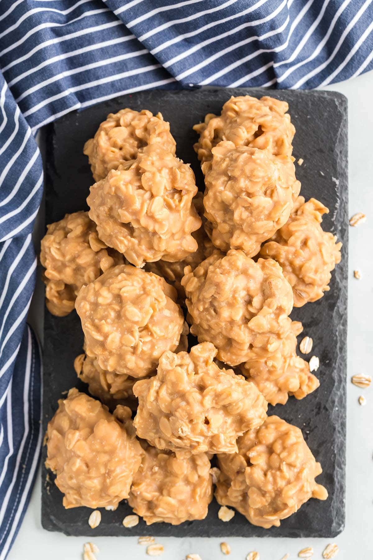 a couple of peanut butter no bake cookies served on a stone board.