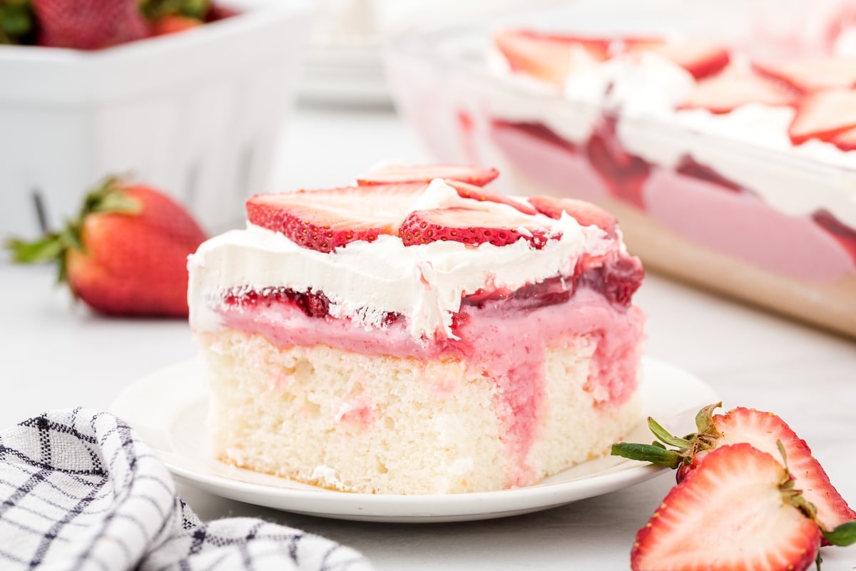 a slice of strawberry poke cake on a plate