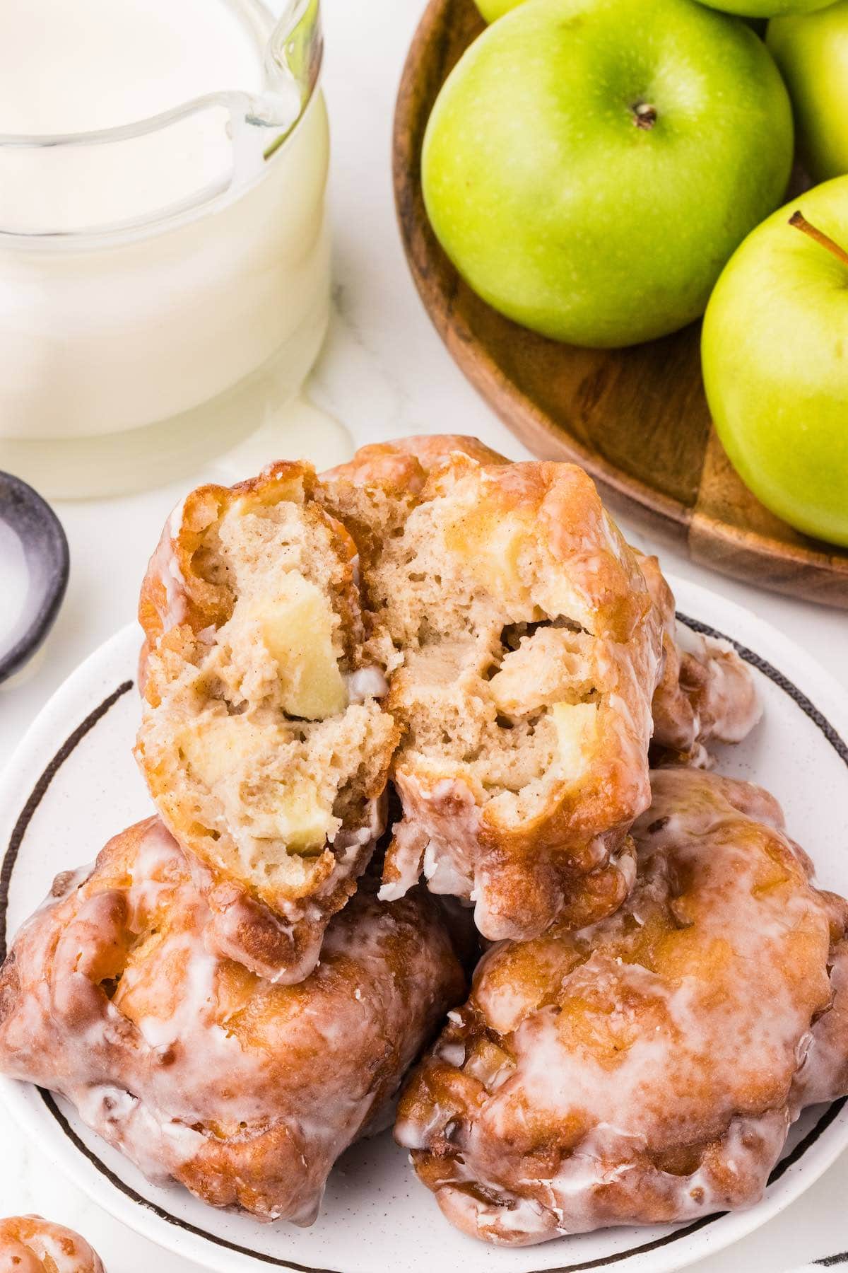 apple fritters stacked on a plate. 