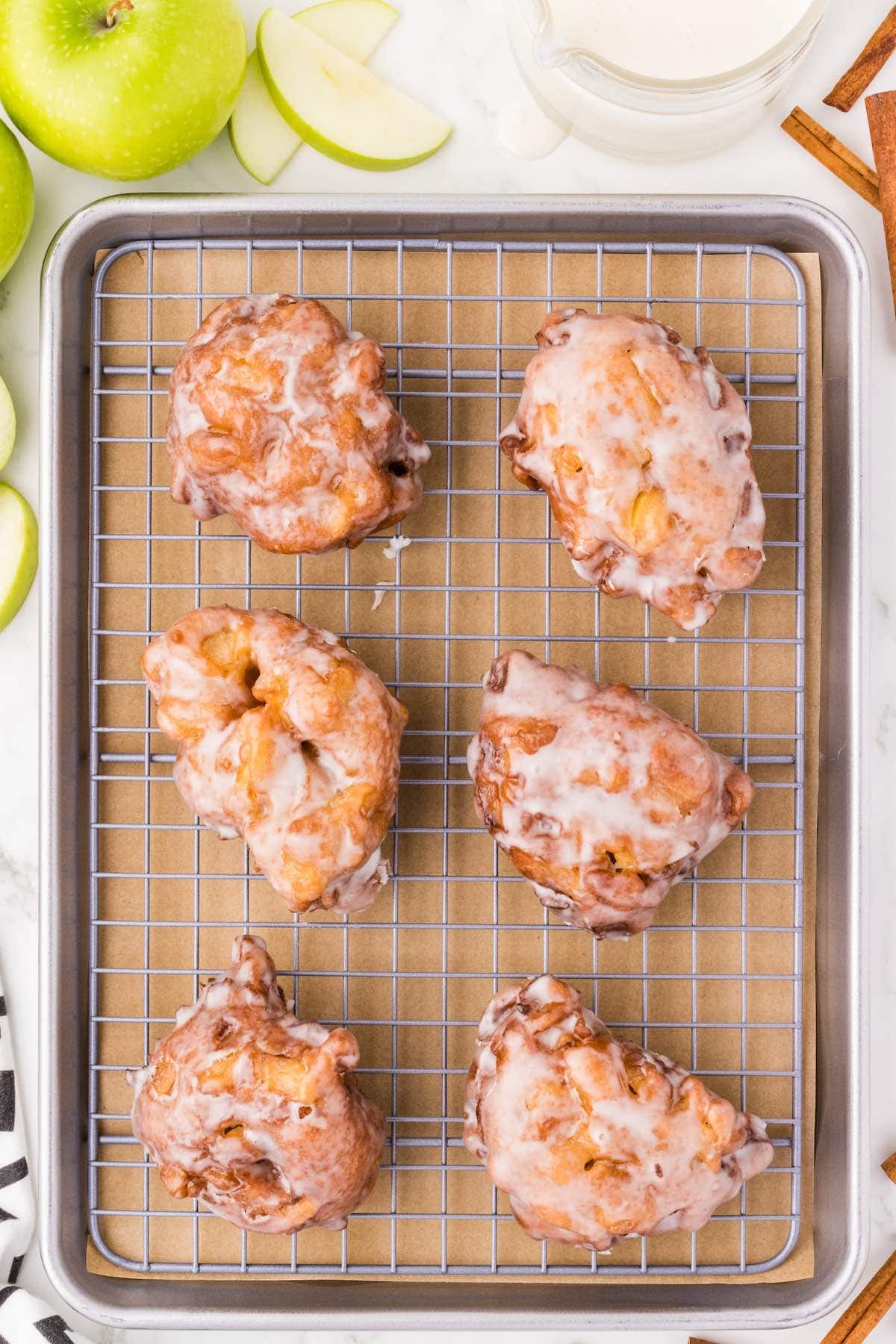 apple fritters on top of cooling rack. 