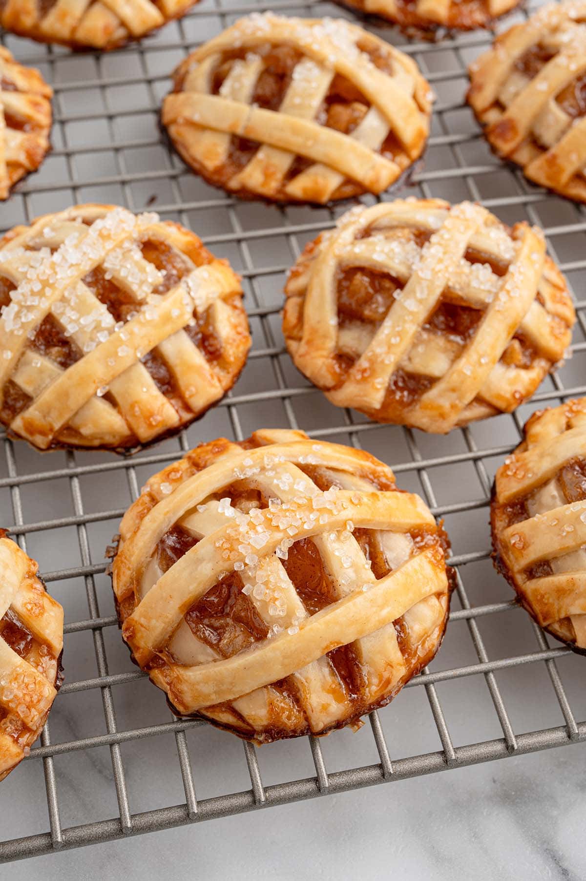 a couple of apple pie cookies on a cooling rack.