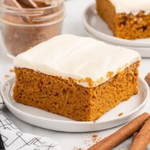 a square piece of pumpkin bars on top of white plate.