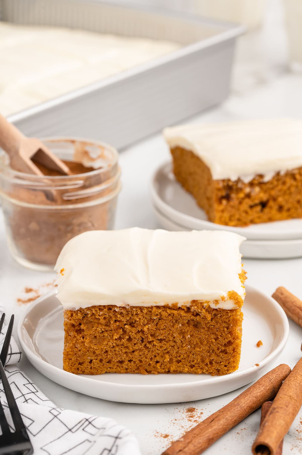 a slice of Pumpkin Bars with cream cheese frosting on a white plate.