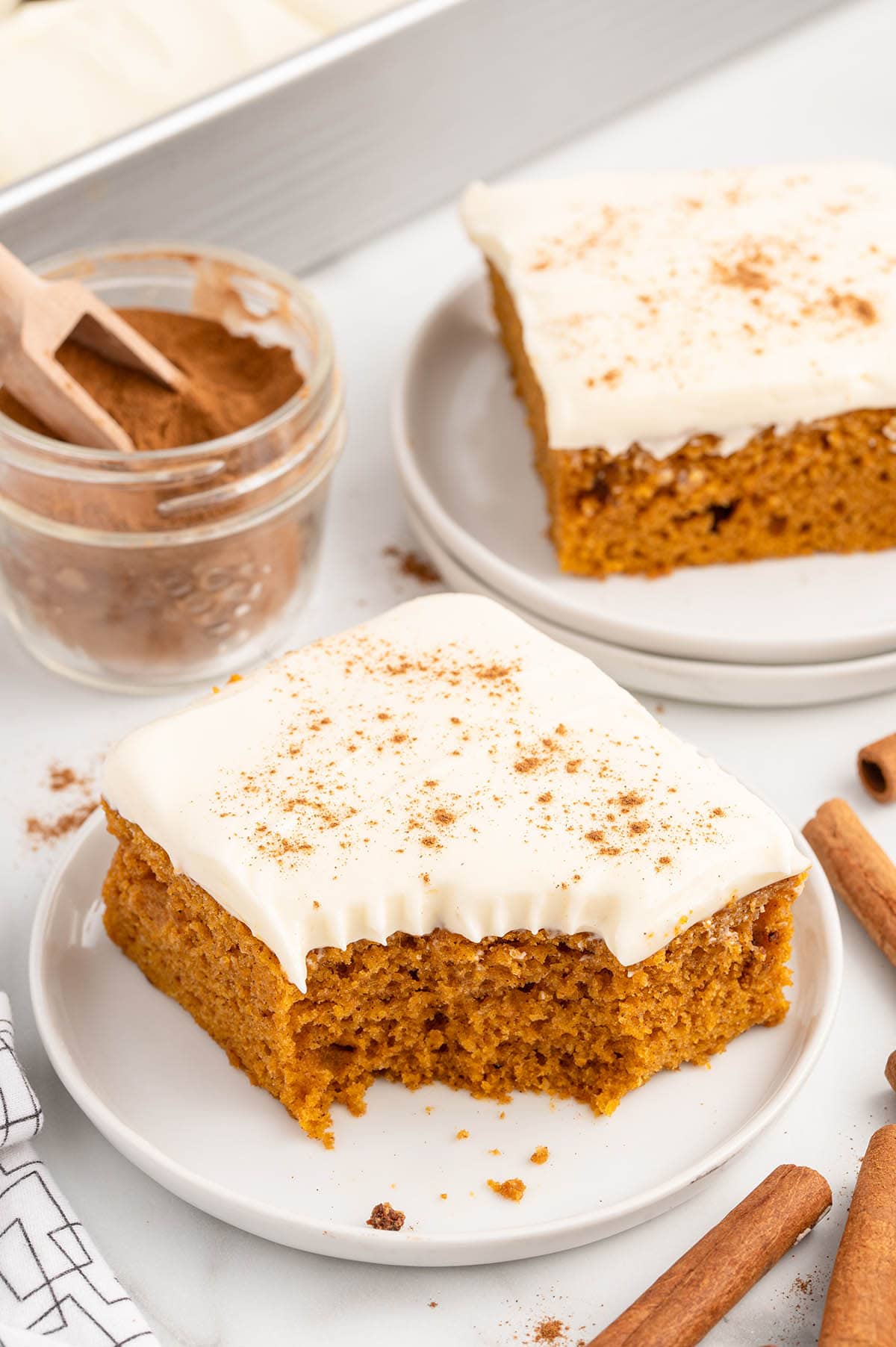 a slice of Pumpkin Bars with cream cheese frosting on a white plate.