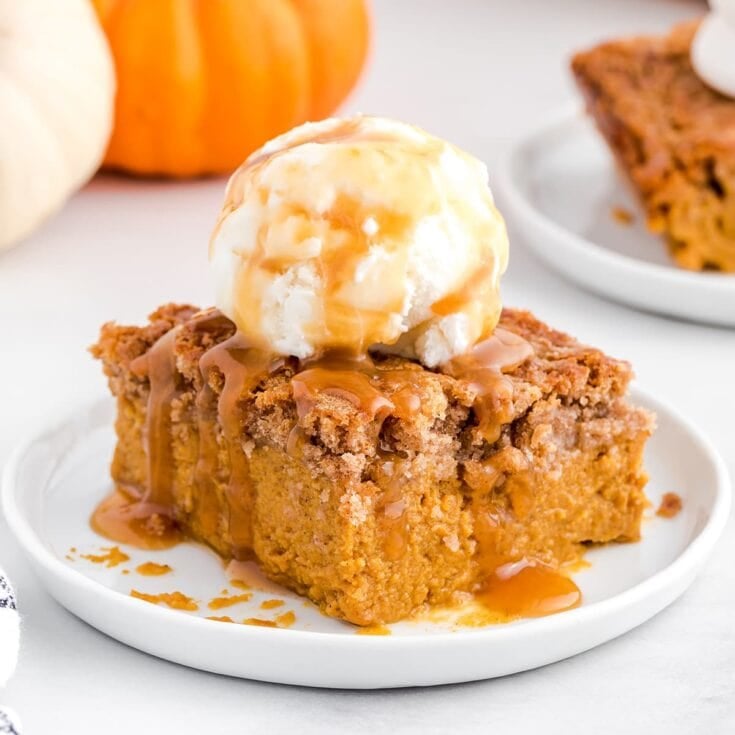 Pumpkin dump cake topped with vanilla ice cream and caramel sauce.