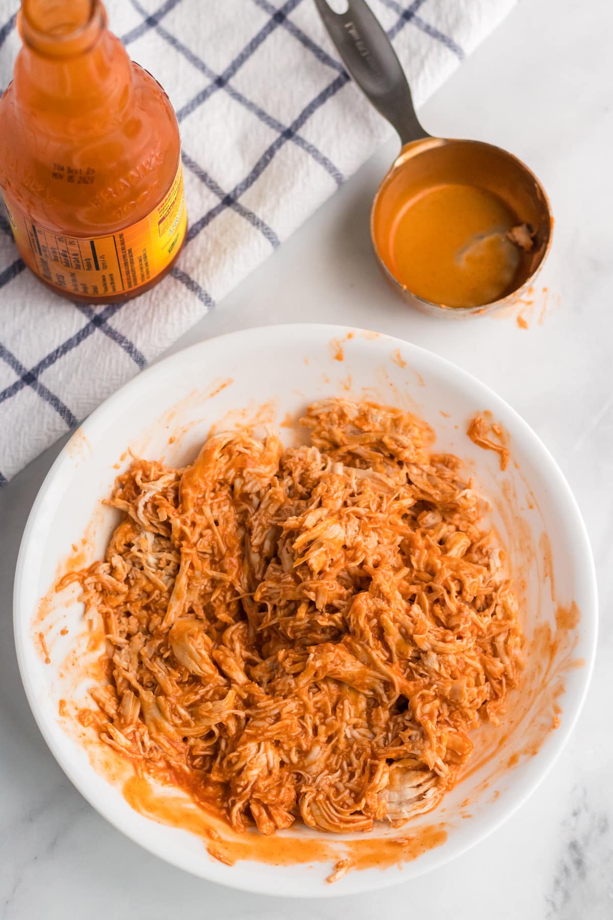 Pour buffalo sauce on top of shredded chicken and mix well.