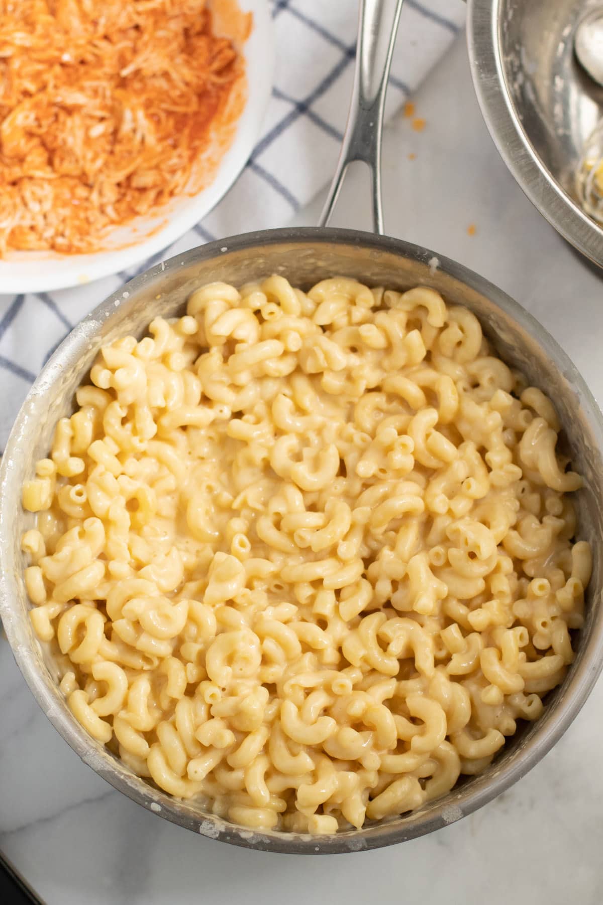 Combine cooked macaroni and shredded chicken in the pan with the sauce