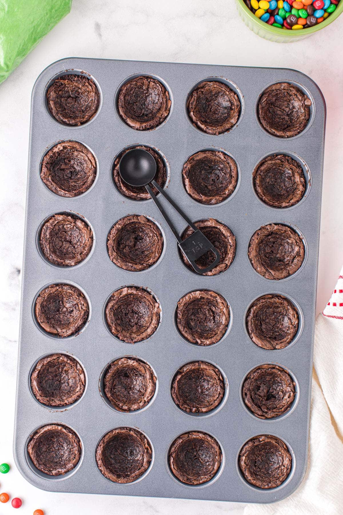 Use a teaspoon to create an indentation on the top of each baked brownie