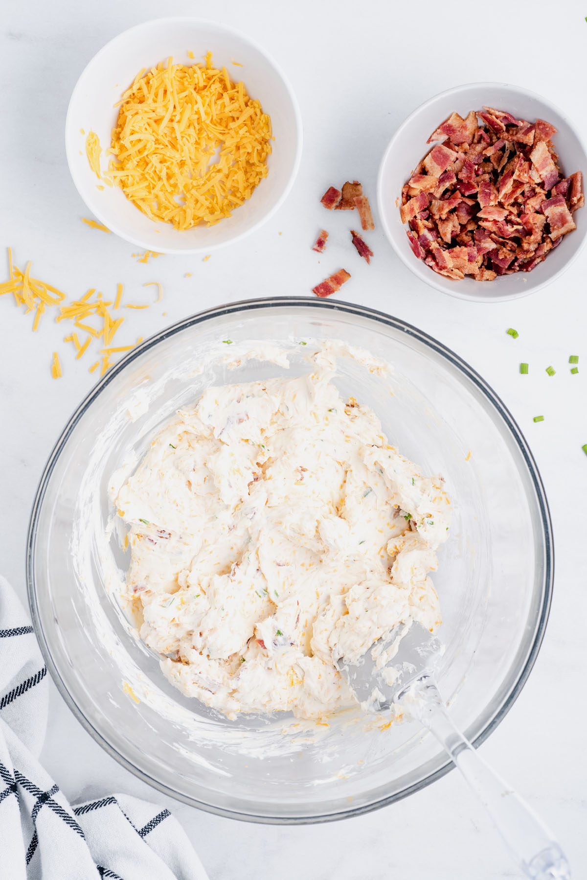 Fold cheddar cheese and ½ cup of the bacon crumbles into the cream cheese mixture 