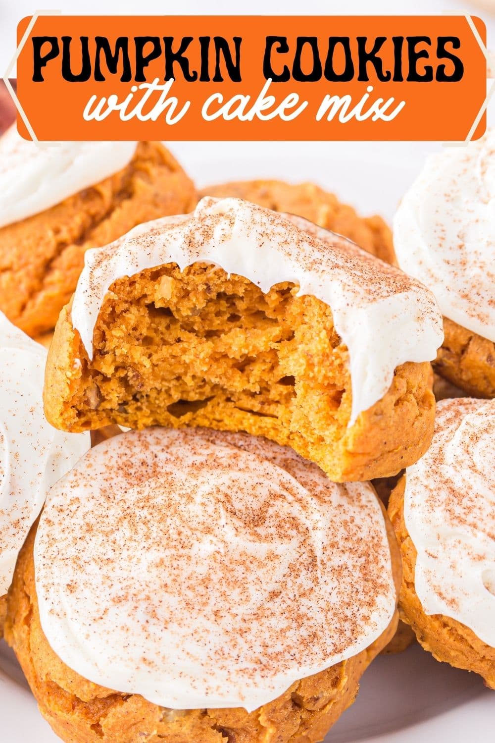 A stack of pumpkin cake mix cookies with one piece being half bitten