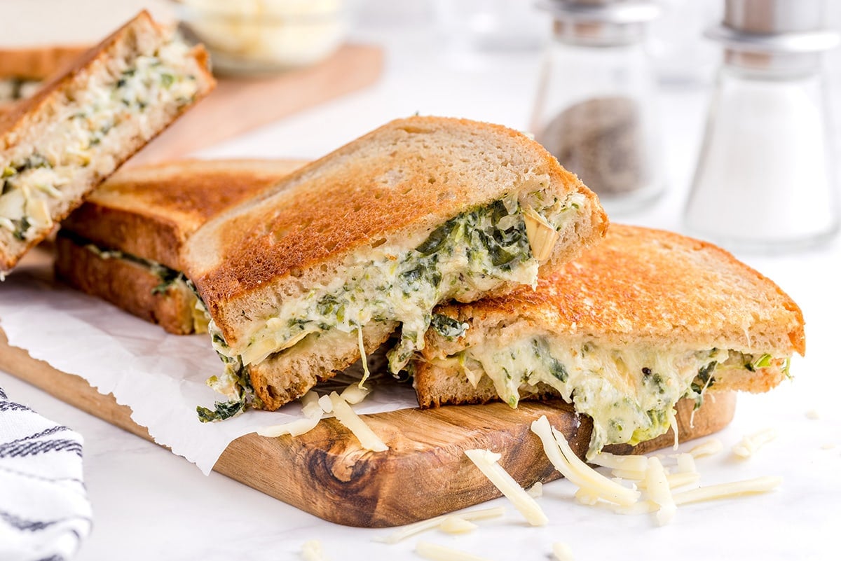 spinach and artichoke grilled cheese on wood board