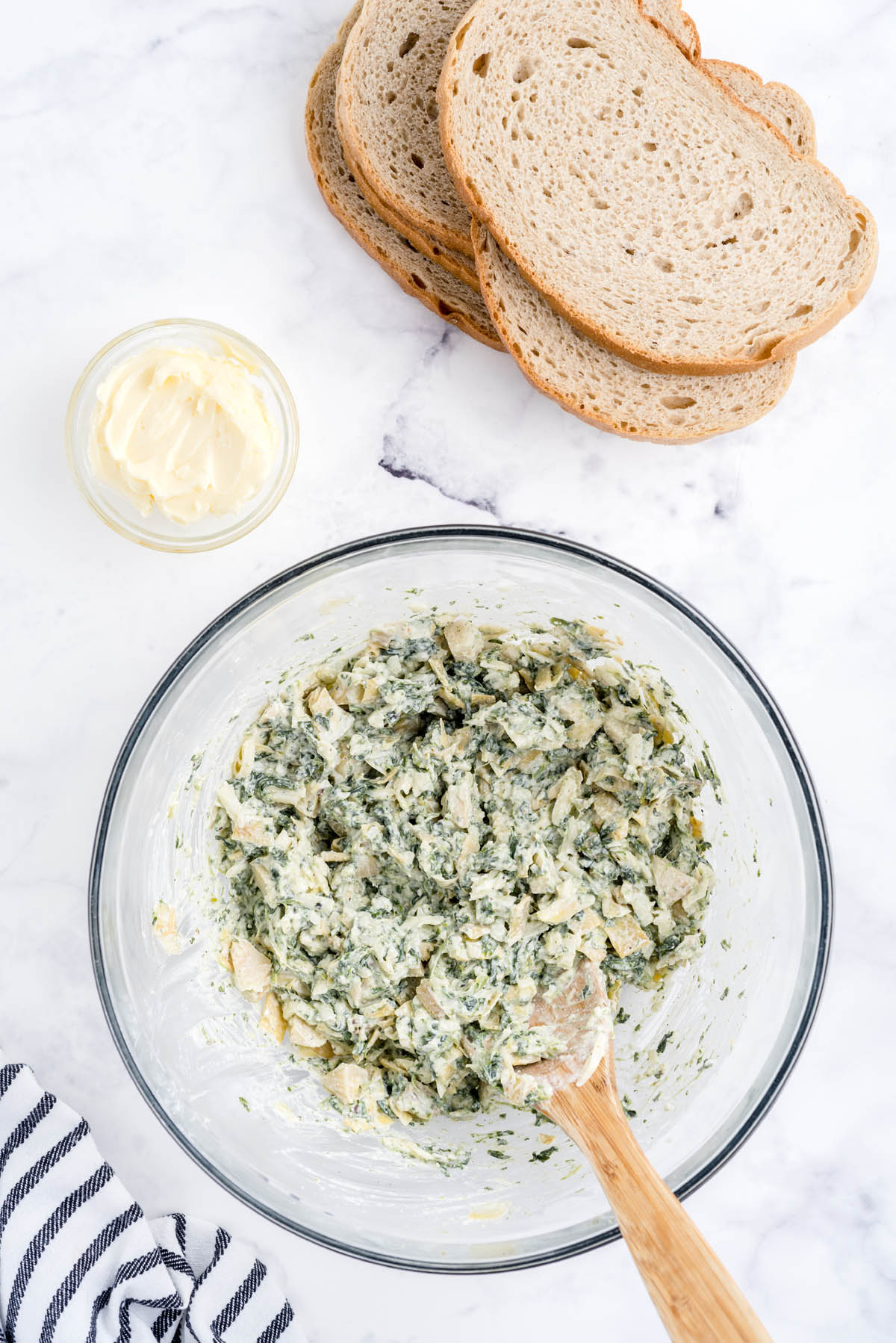 Mix together spinach, artichoke hearts, mayonnaise, sour cream, cream cheese, mozzarella cheese, cheddar cheese, parmesan cheese, onion powder, kosher salt, and pepper until well combined.