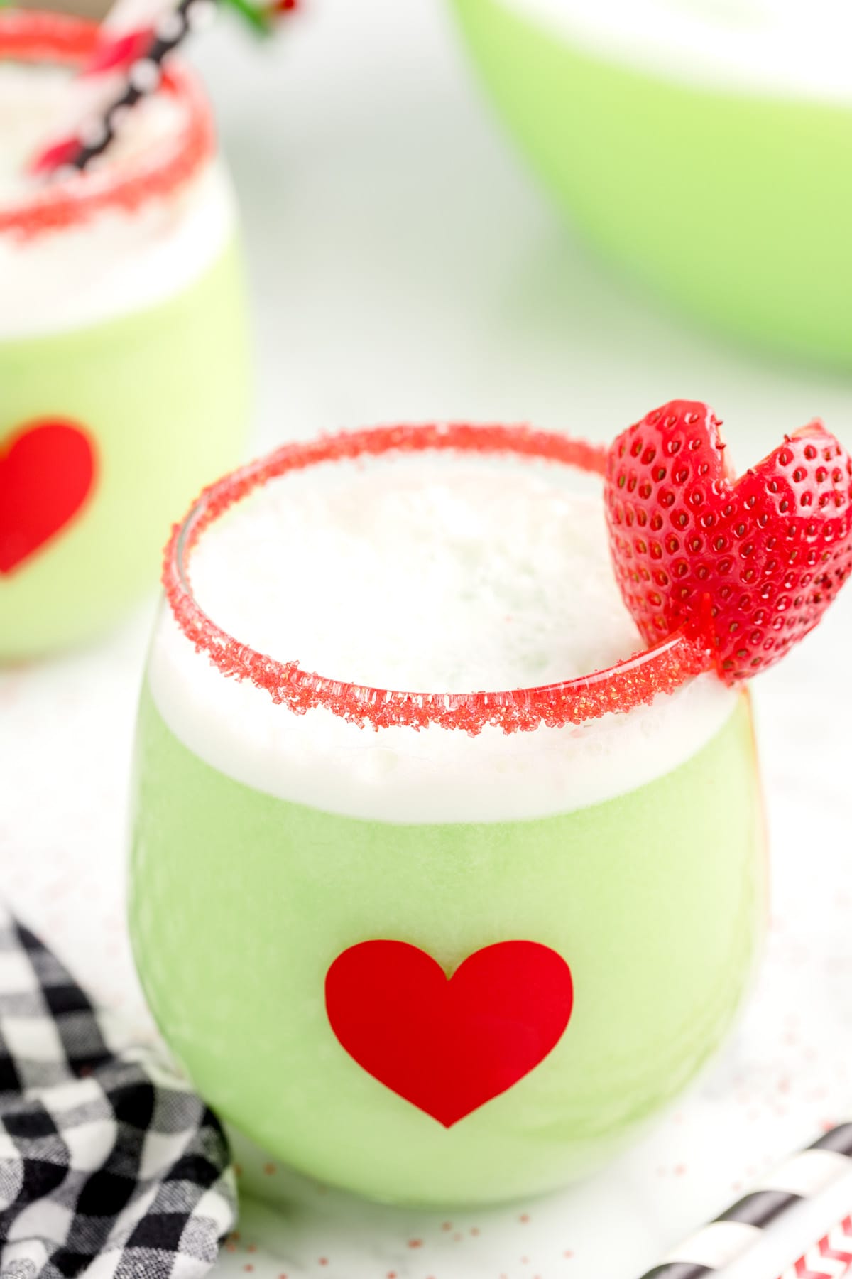 grinch punch in a glass garnish with a slice of strawberry