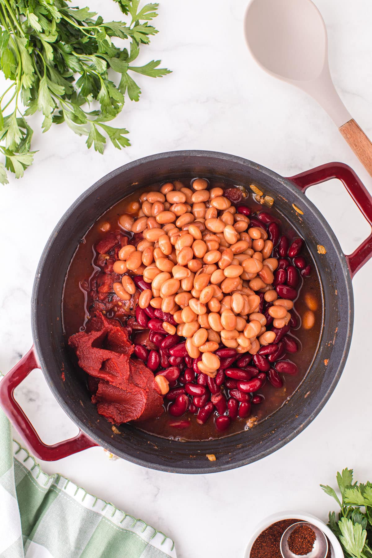 Mix in the kidney beans, pinto beans, fire roasted tomatoes, and tomato paste into the pot