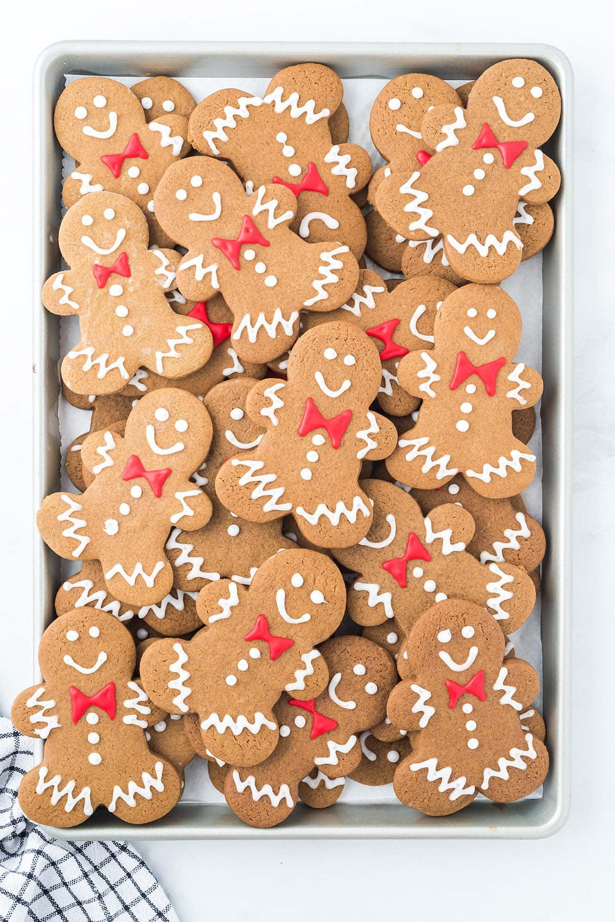 gingerbread men cookies stacked on top of baking tray