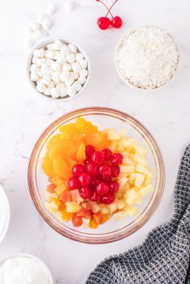 Mix together the tropical fruit, oranges, cherries, and pineapple