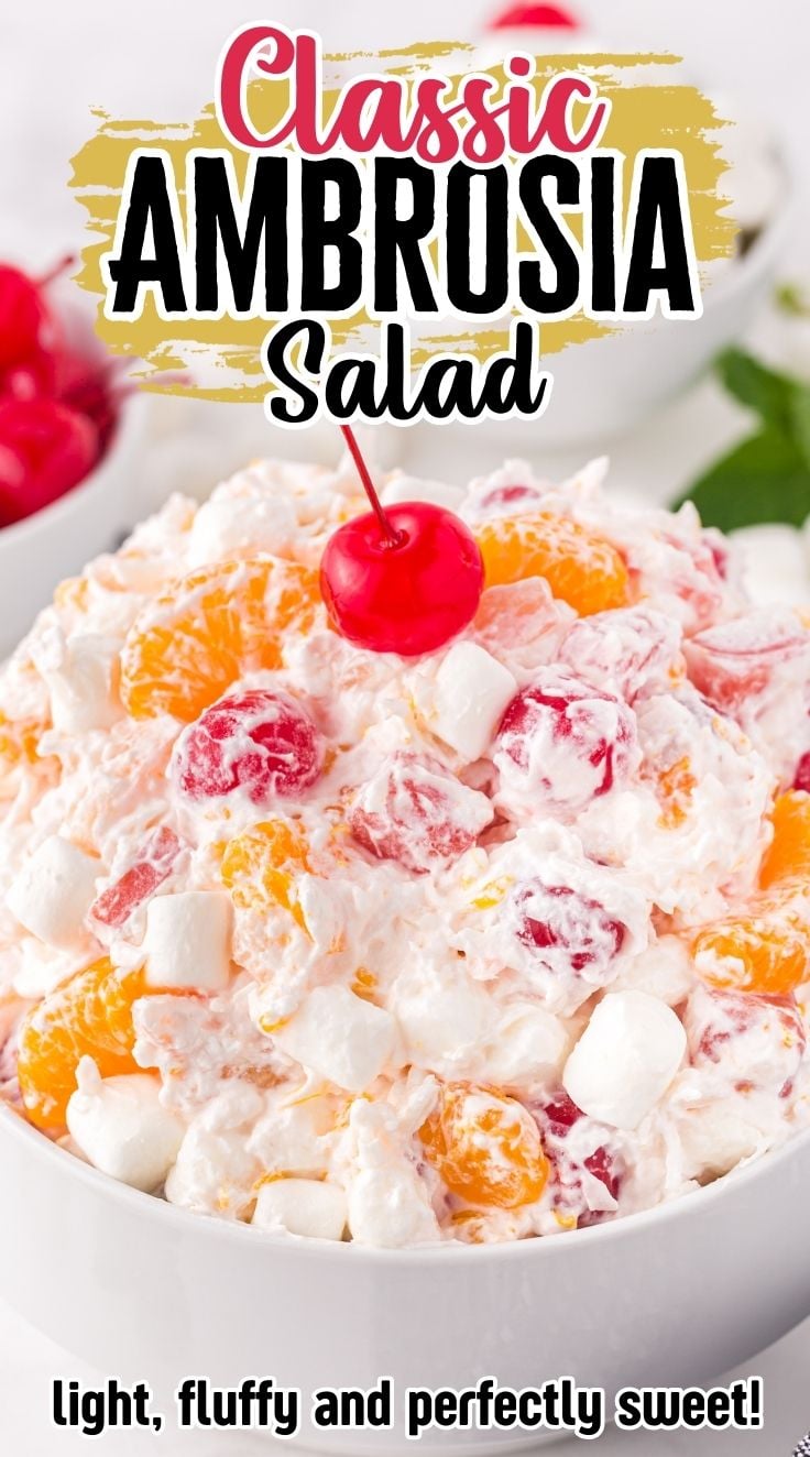 Creamy and fluffy ambrosia salad topped with a cherry served in a white bowl