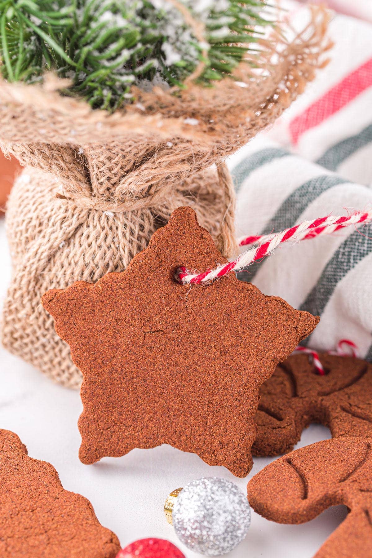 cinnamon Christmas ornaments in the shape of a star with a red and white string attached to it for hanging.