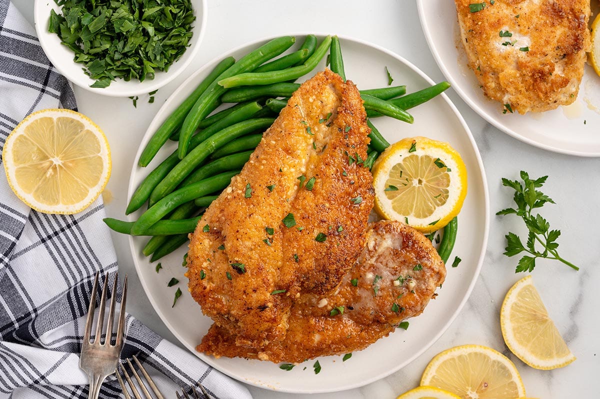 Lemon chicken with green beans, parsley, and fresh lemon slices.