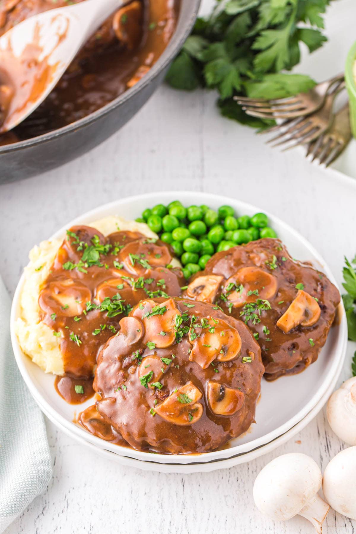 A bowl of food on a plate, with Salisbury steak