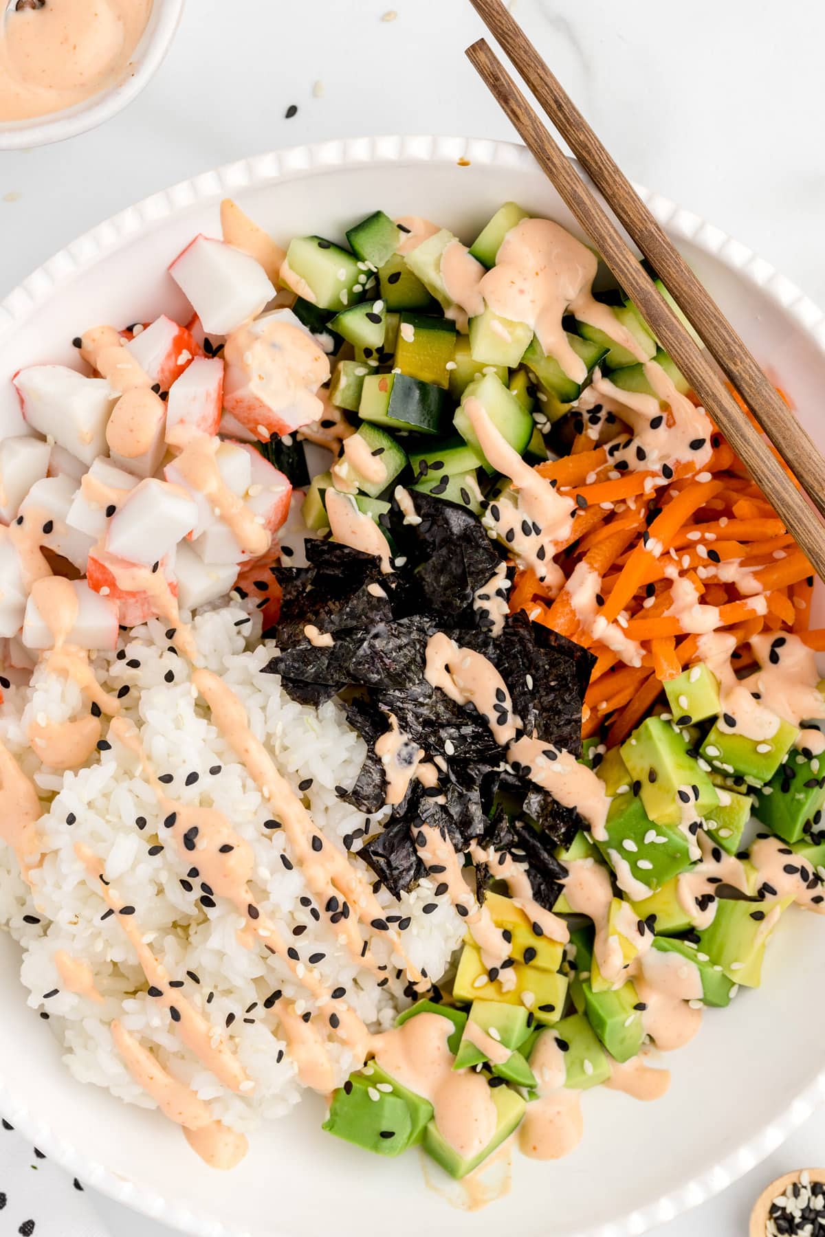 A plate of food, with California roll sushi bowl