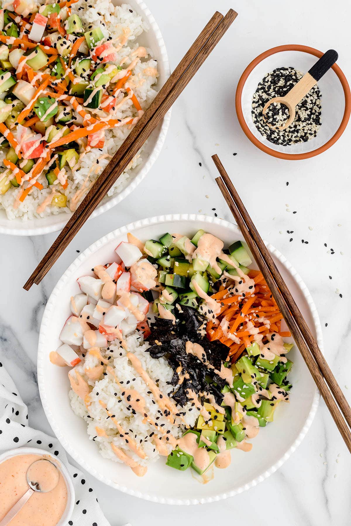 A bowl of food on a plate, with Sushi and Rice
